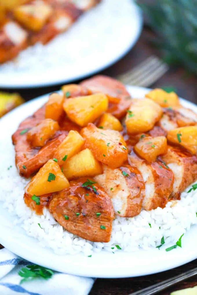 sliced chicken breast topped with pineapple on top of rice