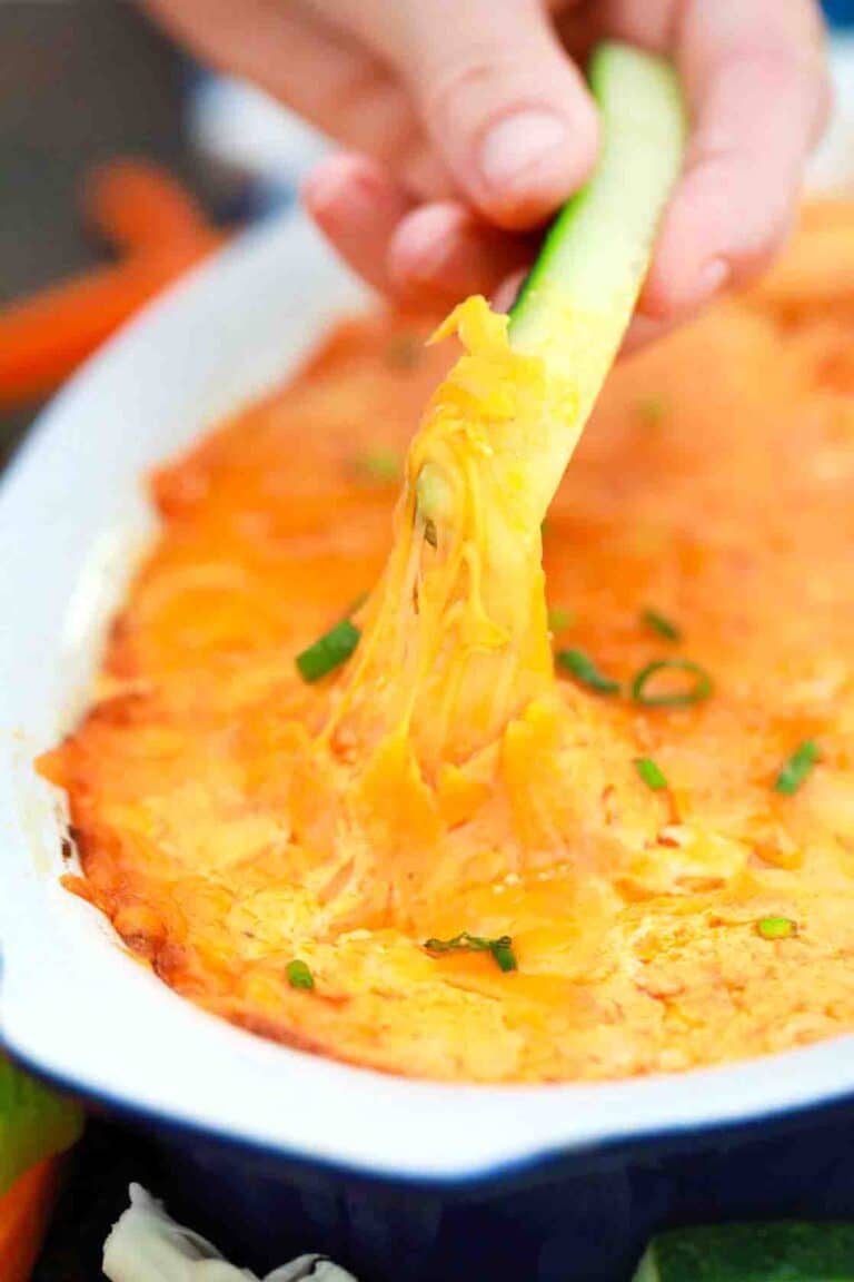 dipping a cucumber stick into pressure cooker buffalo chicken dip