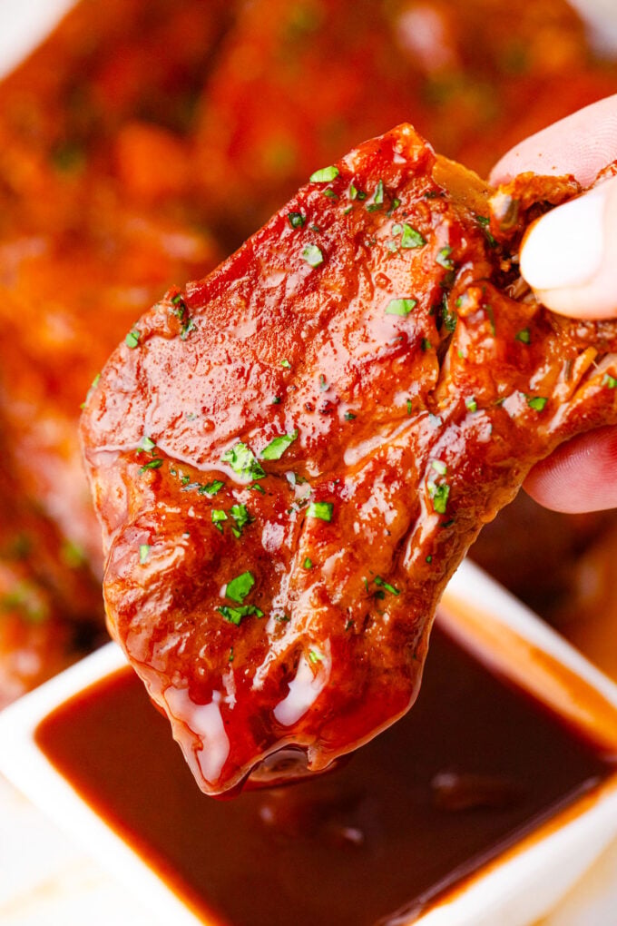 Dipping Instant Pot country style ribs in BBQ sauce.