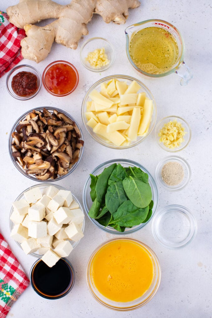 Overhead shot of Instant Pot hot and sour soup ingredients in bowls on a table.