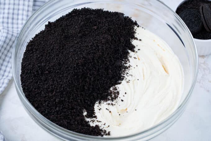 Stirring Oreo crumbs into buttercream.