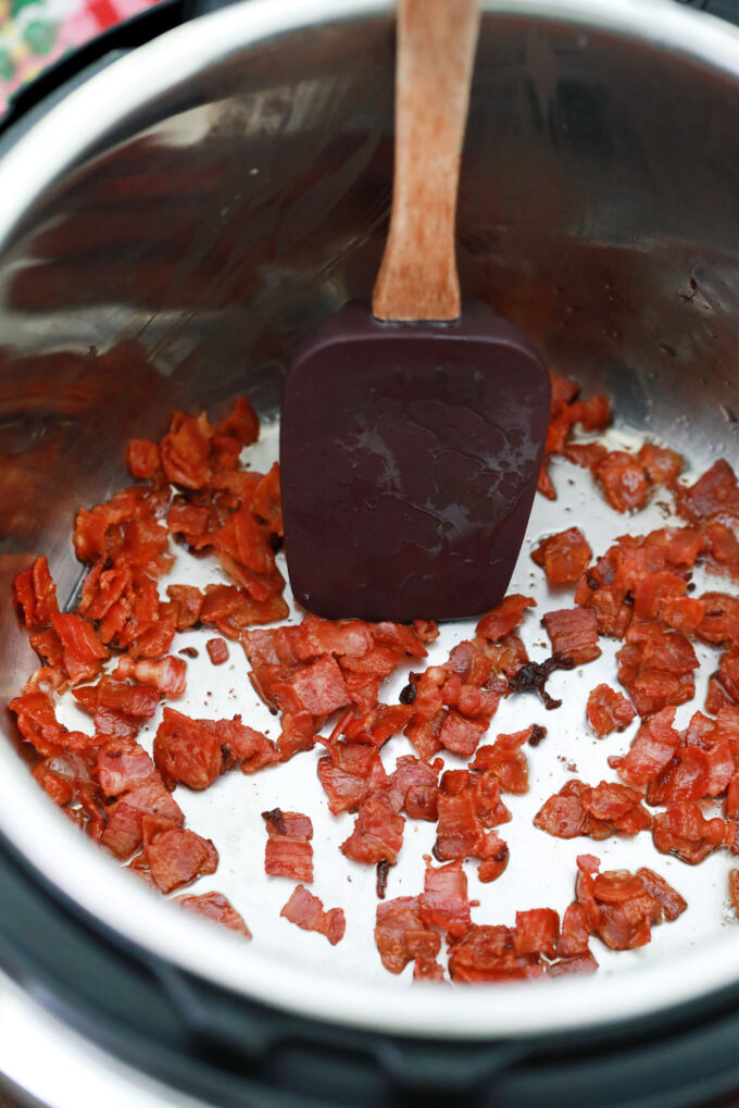 SautƩing bacon pieces in the instant pot.