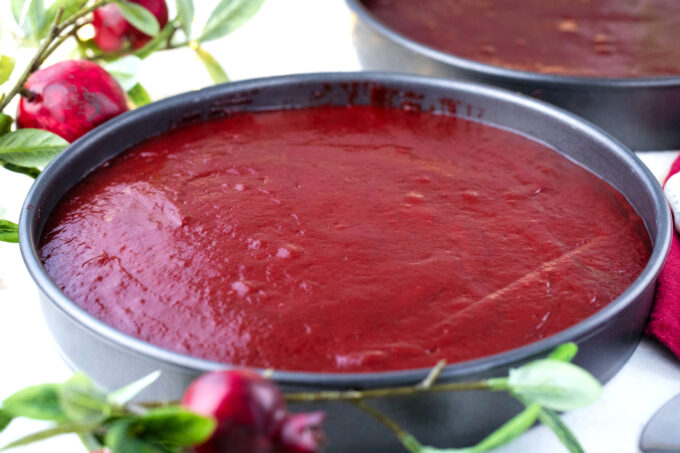 Red velvet cake batter in round baking pans.
