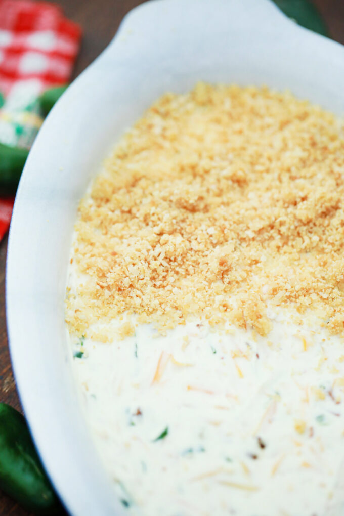 Assembling jalapeno popper dip with buttery topping.