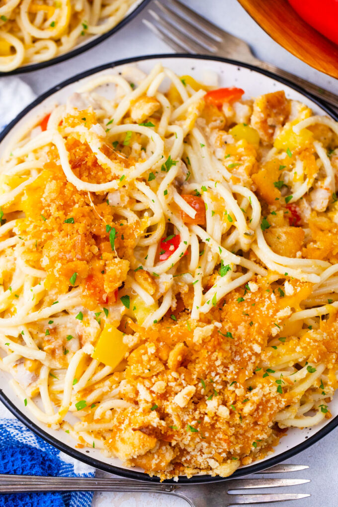 Overhead shot of a dinner plate of baked chicken spaghetti casserole with cracker topping.