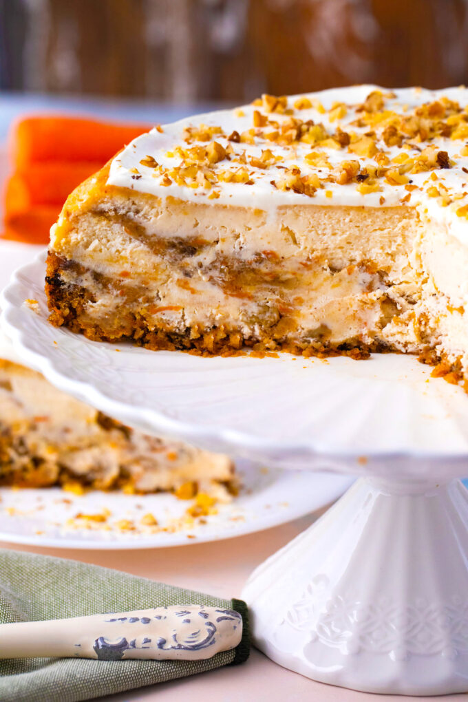 Sliced carrot cake cheesecake on a cake stand.