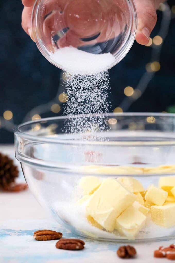 adding sugar to a bowl with butter