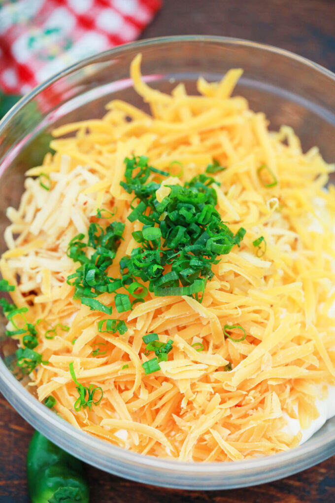 Combining jalapeno popper dip ingredients in a bowl.