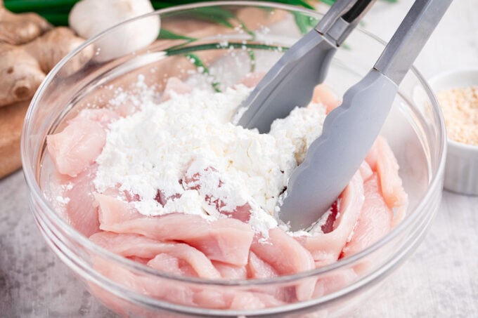 Coating chicken strips in cornstarch.