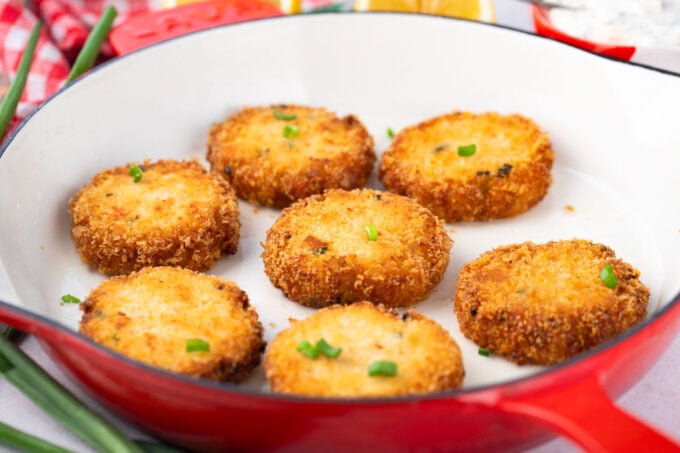 Crispy crab cakes in a frying pan.