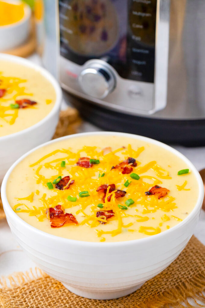 Bowls of Instant Pot loaded baked potato soup with bacon.
