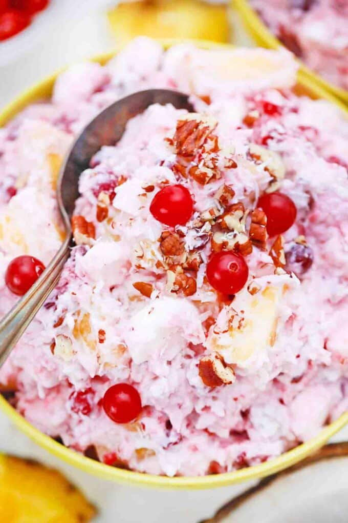 a bowl with a spoon in creamy mllionaire cranberry salad