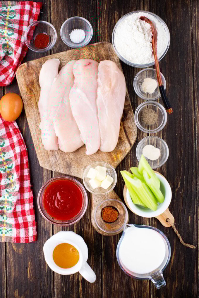 Overhead shot of crispy boneless chicken wings ingredients arranged on a wooden surface.