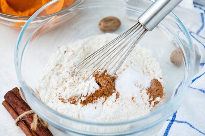 Mixing flour with spices in a bowl.