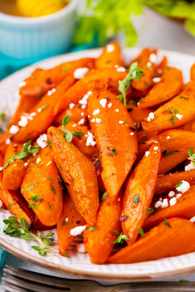 A plate with brown sugar roasted carrots with goat cheese crumbles.