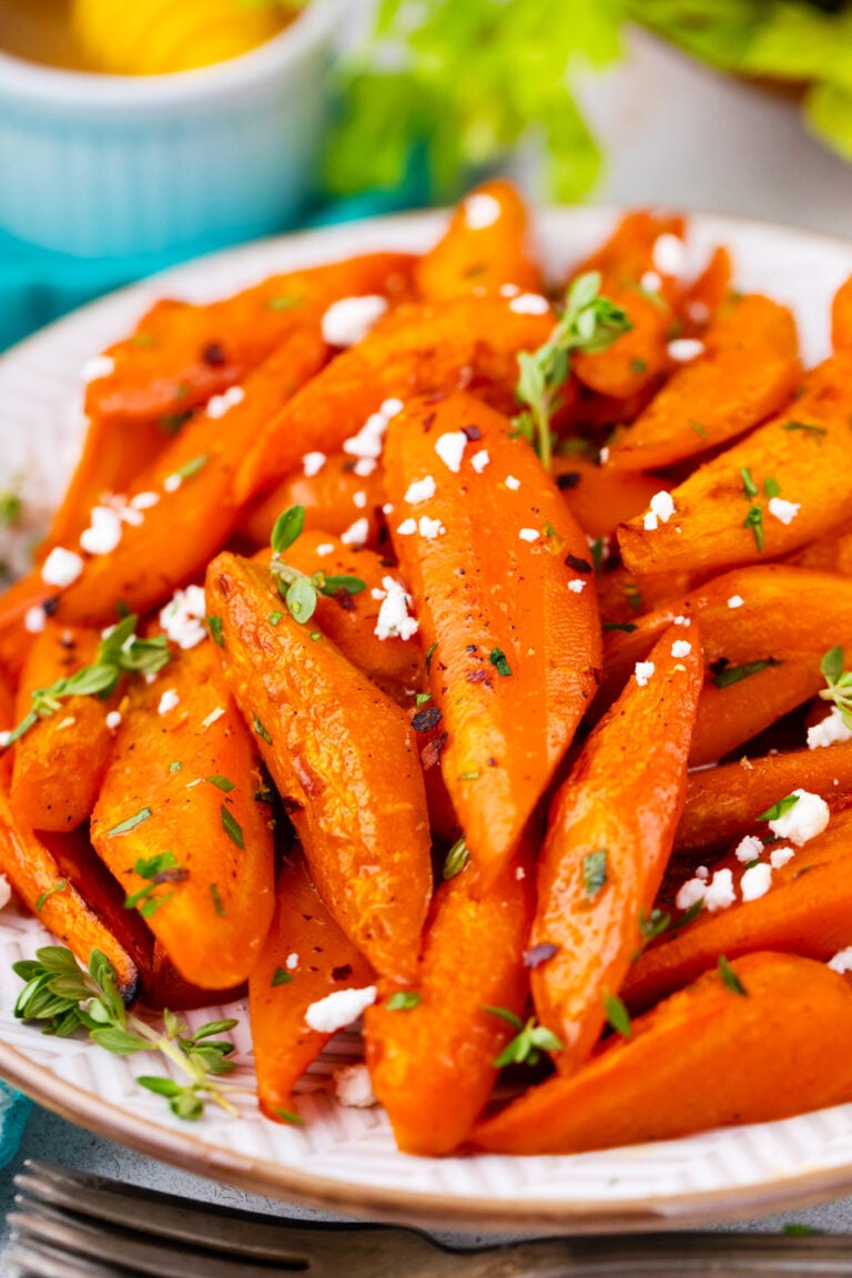 A plate with brown sugar roasted carrots with goat cheese crumbles.