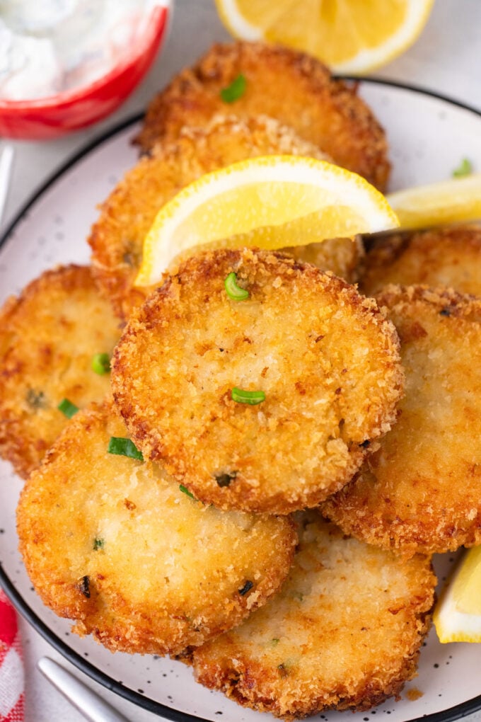 Golden crab cakes served with a lemon wedge.