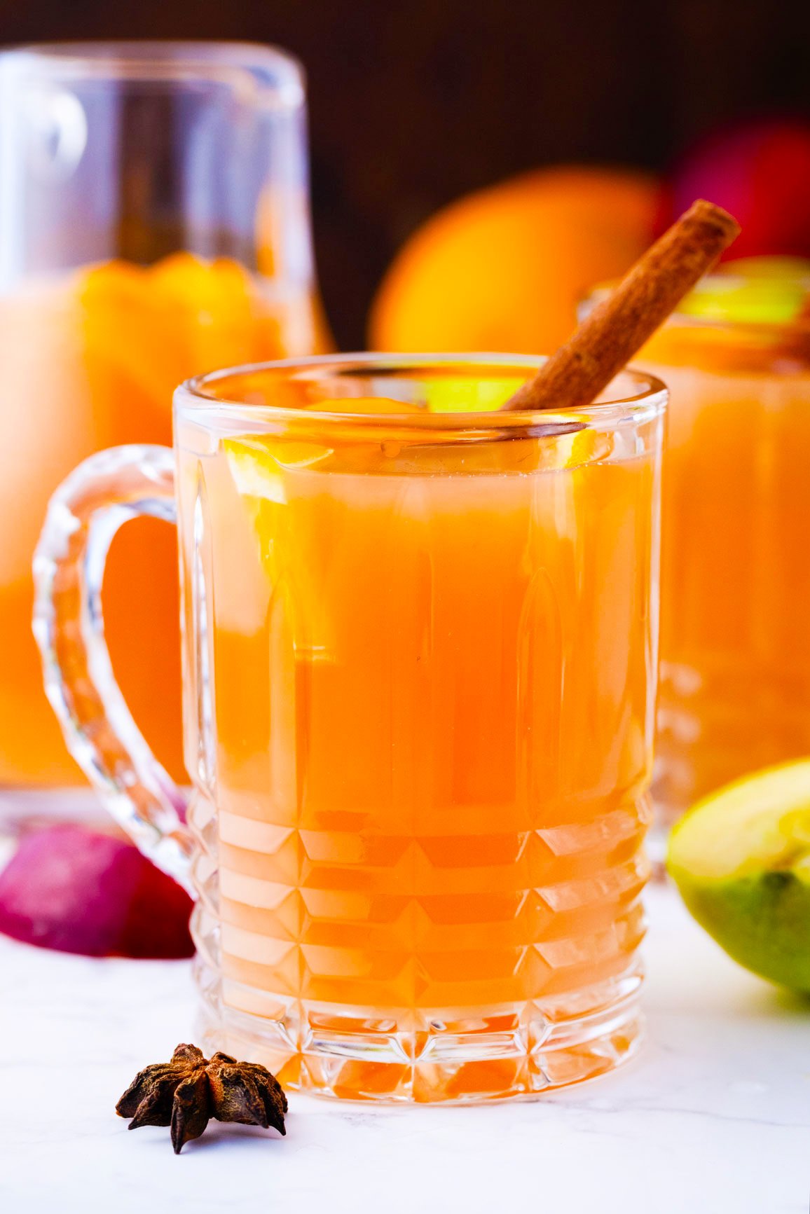 A glass of homemade apple cider with cinnamon sticks.