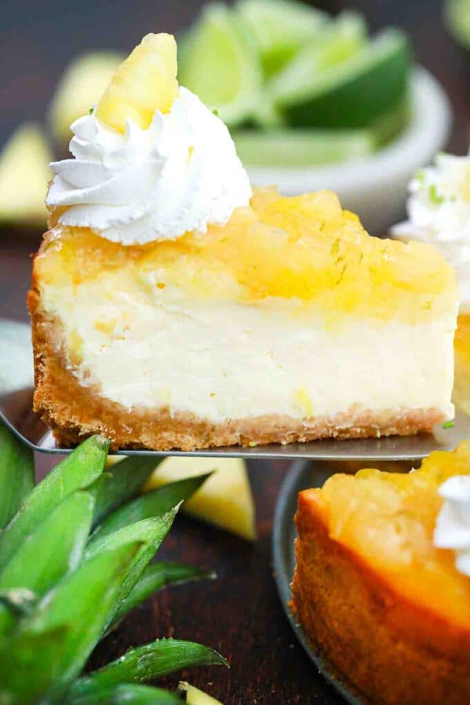 lifting a slice of pineapple cheesecake on a serving spatula