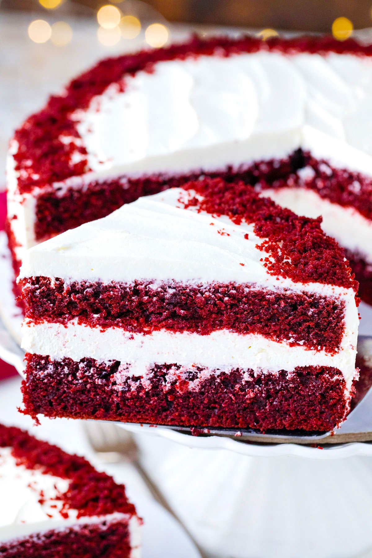 A slice of homemade red velvet cake on a serving spatula.