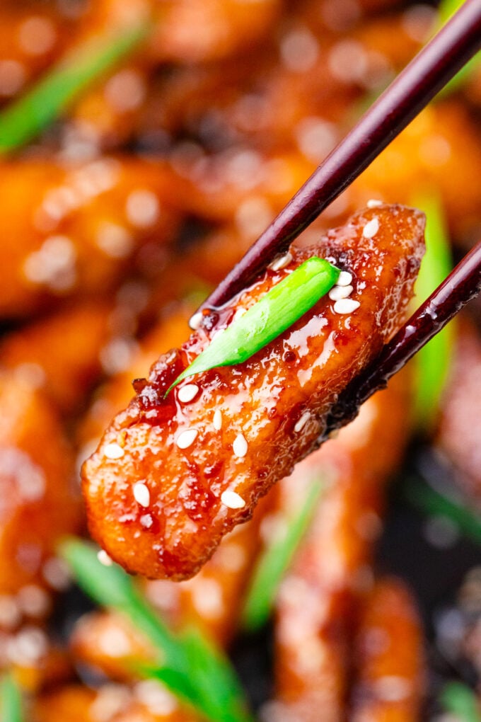 Holding a piece of crispy Mongolian chicken.