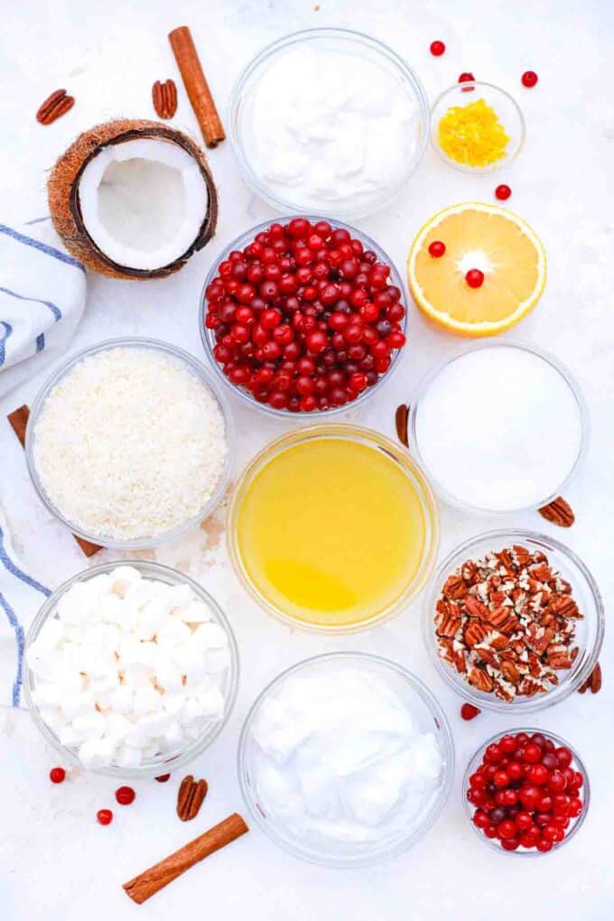 overhead shot of cranberries orange juice pineapple marshmallows coconut on a table