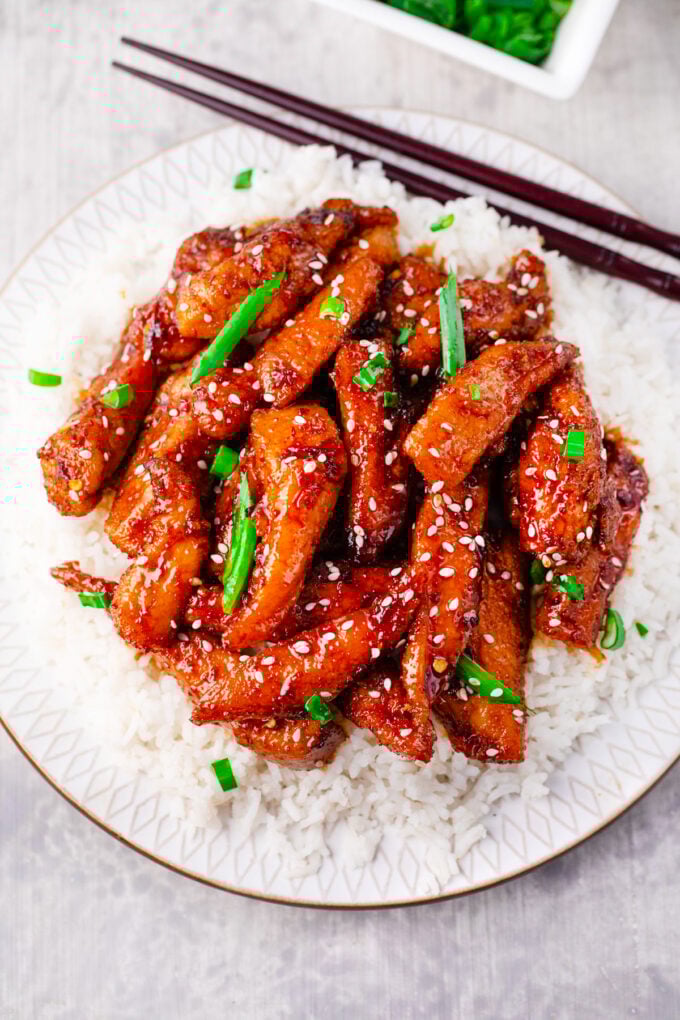 Overhead shot of Mongolian chicken with sesame seeds and green onions over white rice.