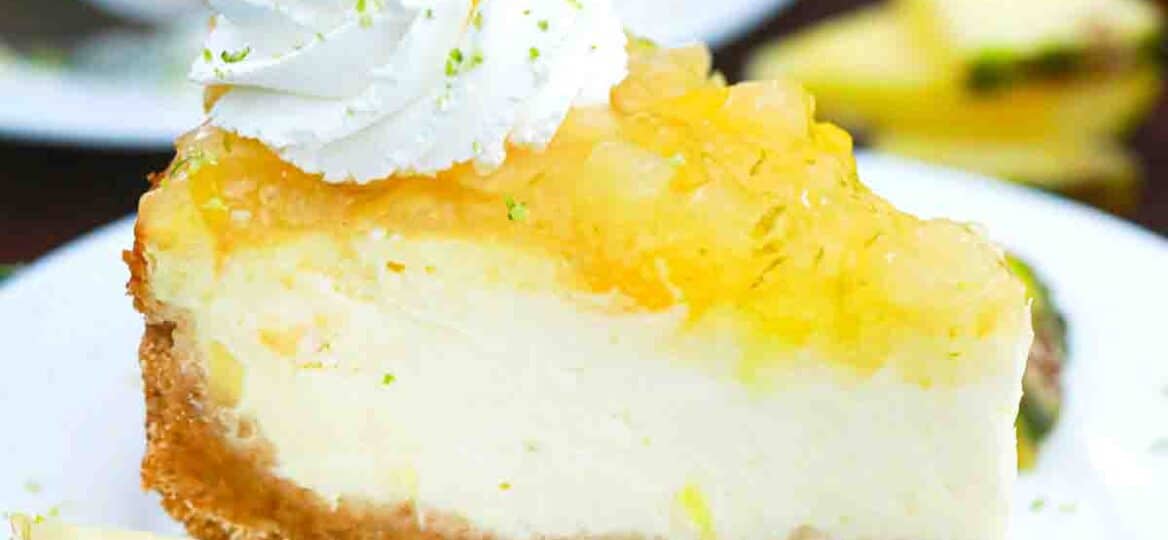 pineapple cheesecake slice with pineapple topping and garnished with whipped cream