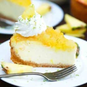 pineapple cheesecake slice with pineapple topping and garnished with whipped cream