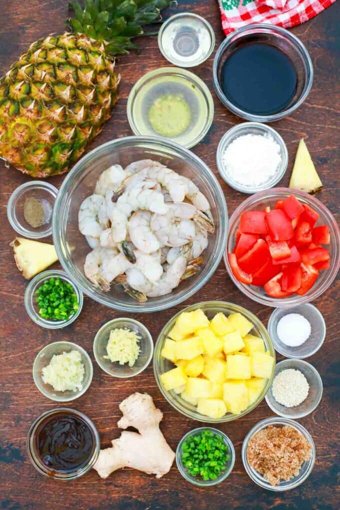 overhead shot of shrimp bell pepper pineapple spices soy sauce in bowls on a table