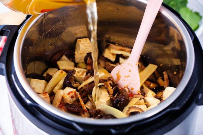 Adding broth to Instant Pot hot and sour soup.