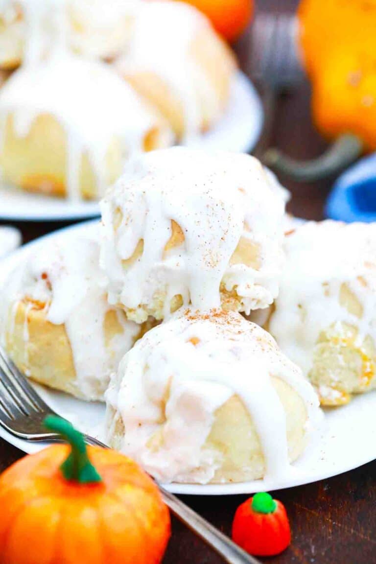 a plate of glazed pumpkin pie cinnamon rolls