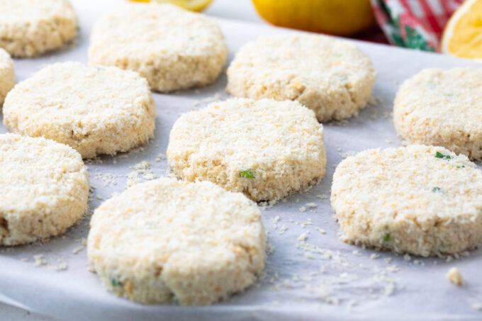 Crab cakes arranged on parchment paper.