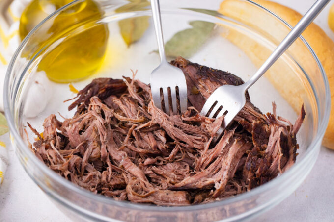 Shredding beef with two forks.