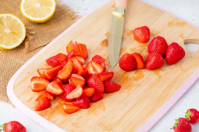 Slicing fresh strawberries on a cutting board.
