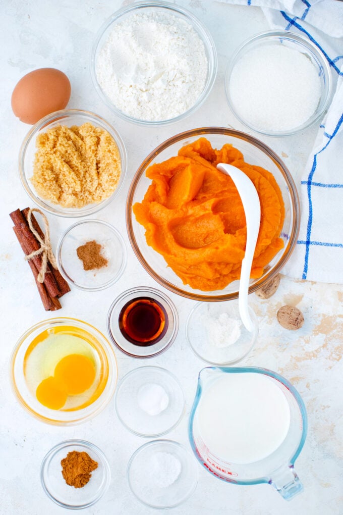 Overhead shot of sweet potato pie cupcakes ingredients in bowls on a white surface.