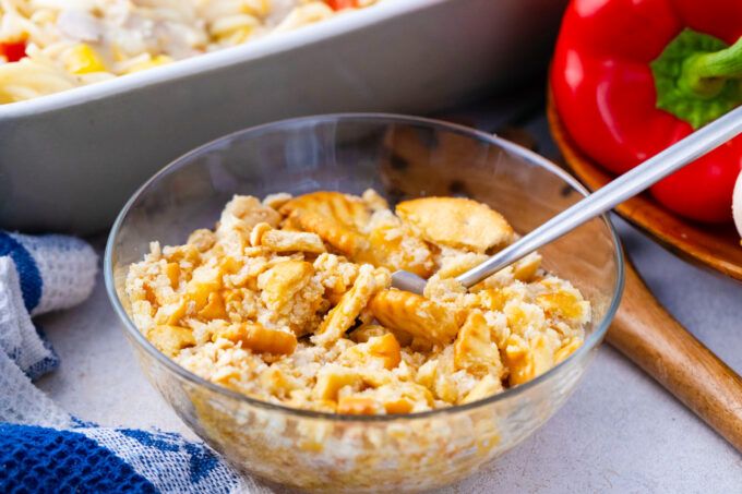 Mixing crushed crackers with butter and cheese.