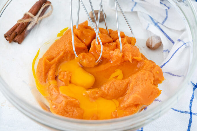 Whisking sweet potato puree and eggs in a bowl.