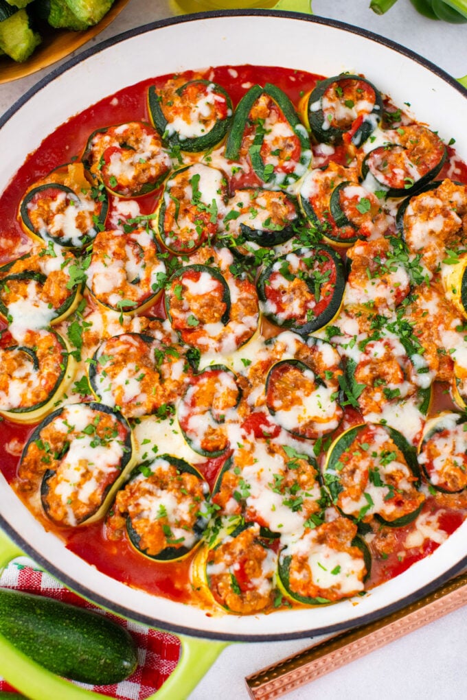 Overhead shot of cheesy zucchini lasagna rollups in marinara sauce.
