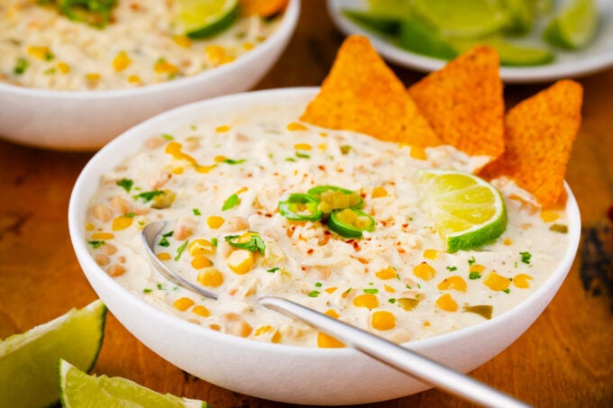 A bowl of cheesy Instant Pot white chicken chili served with lime.