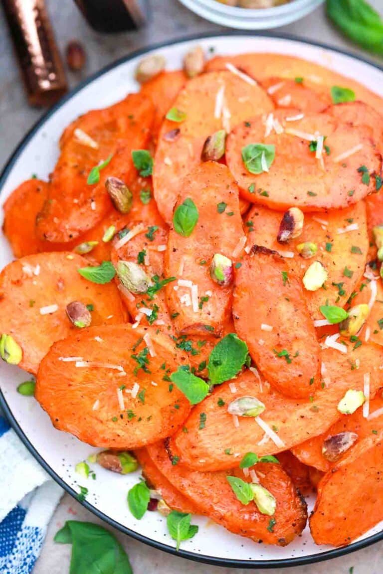 overhead shot of air fried carrot slices topped with pistachios and basil