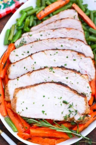 overhead shot of sliced turkey breast with carrots and green beans