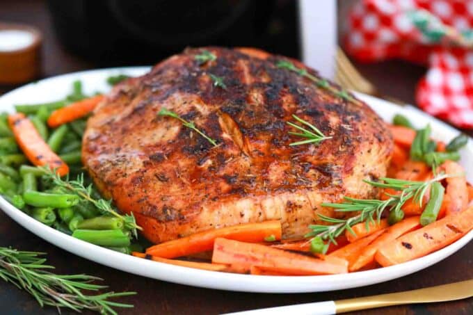 crispy air fryer turkey breast on a platter with roasted veggies