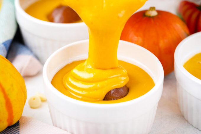 Pouring pumpkin batter over a dollop of dulce de leche to make pumpkin lava cakes.
