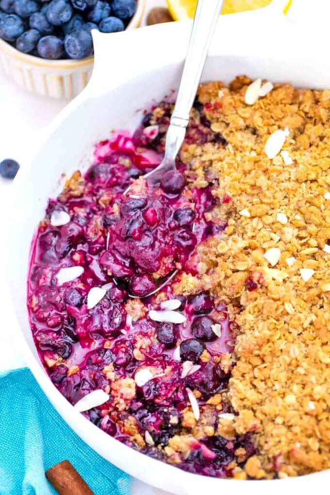 close shot of blueberry crisp with a serving spoon