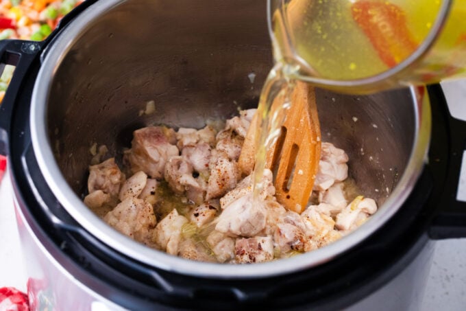 Pouring broth into the Instant Pot.