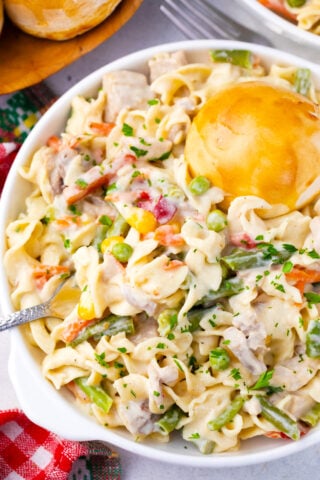Overhead shot of cheesy instant pot chicken pot pie pasta with veggies and biscuit.