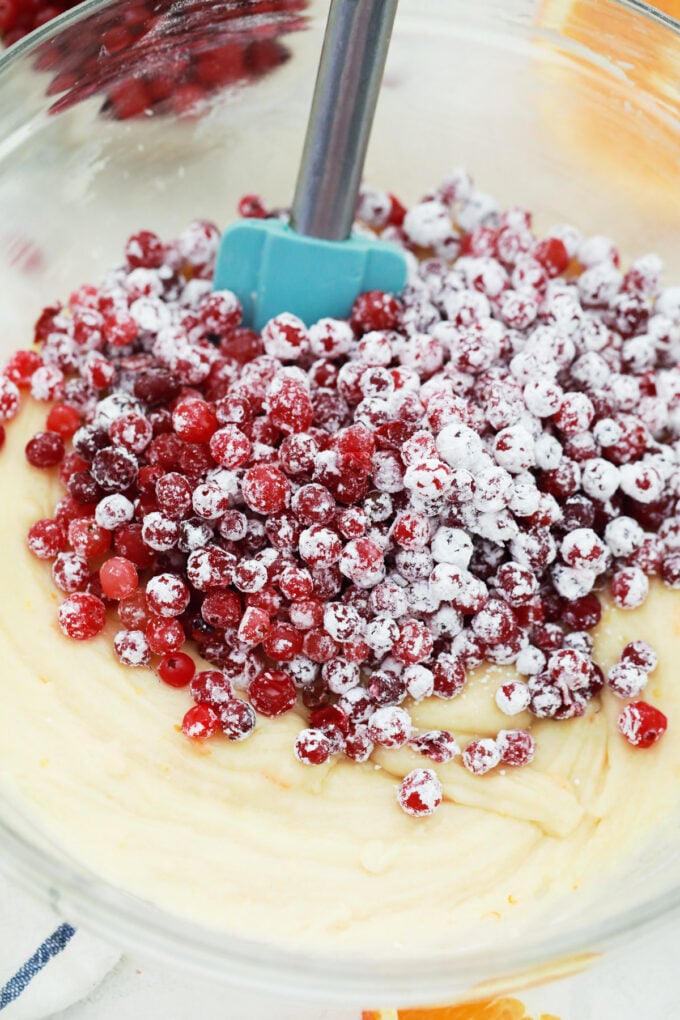 Stirring cranberries into bread batter.