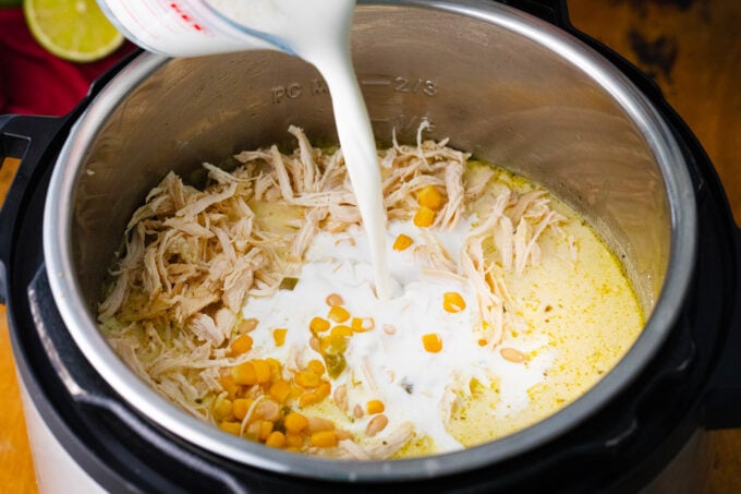 Adding cream to Instant Pot white chicken chili.