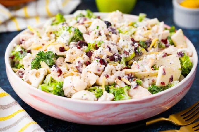 a bowl of creamy broccoli cauliflower salad with fresh broccoli and cauliflower